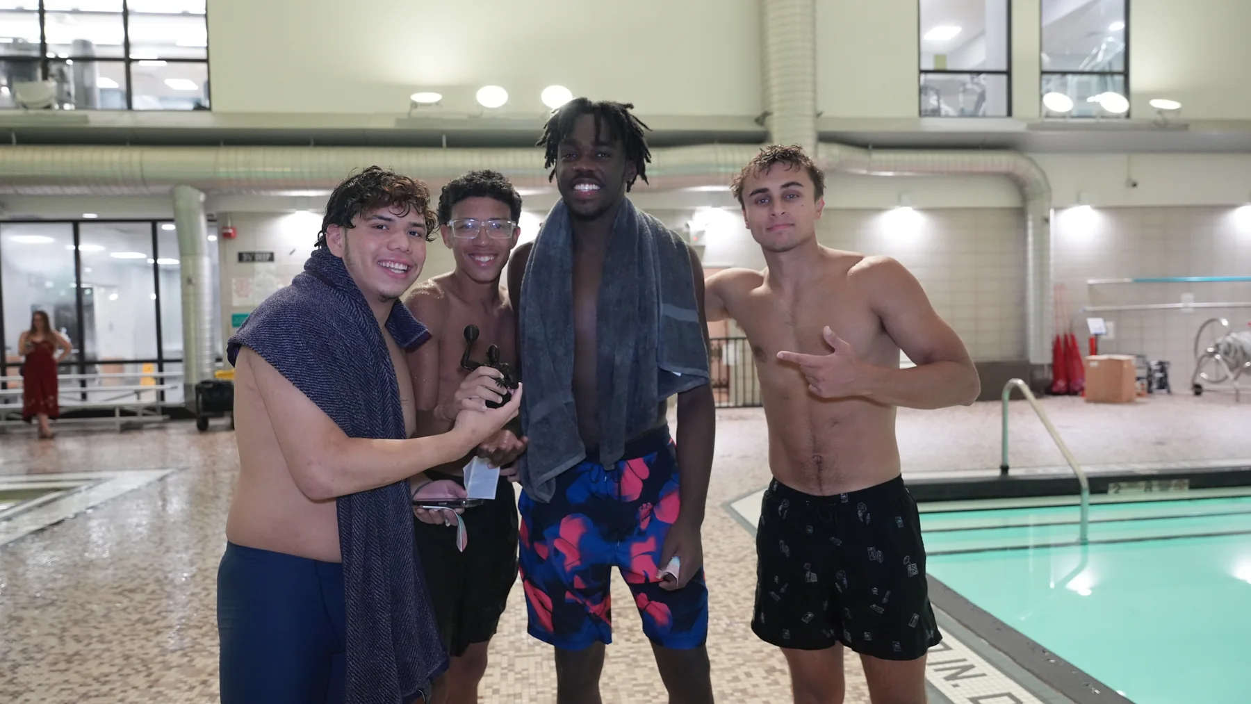 Four Railball participants smile together beside the pool.