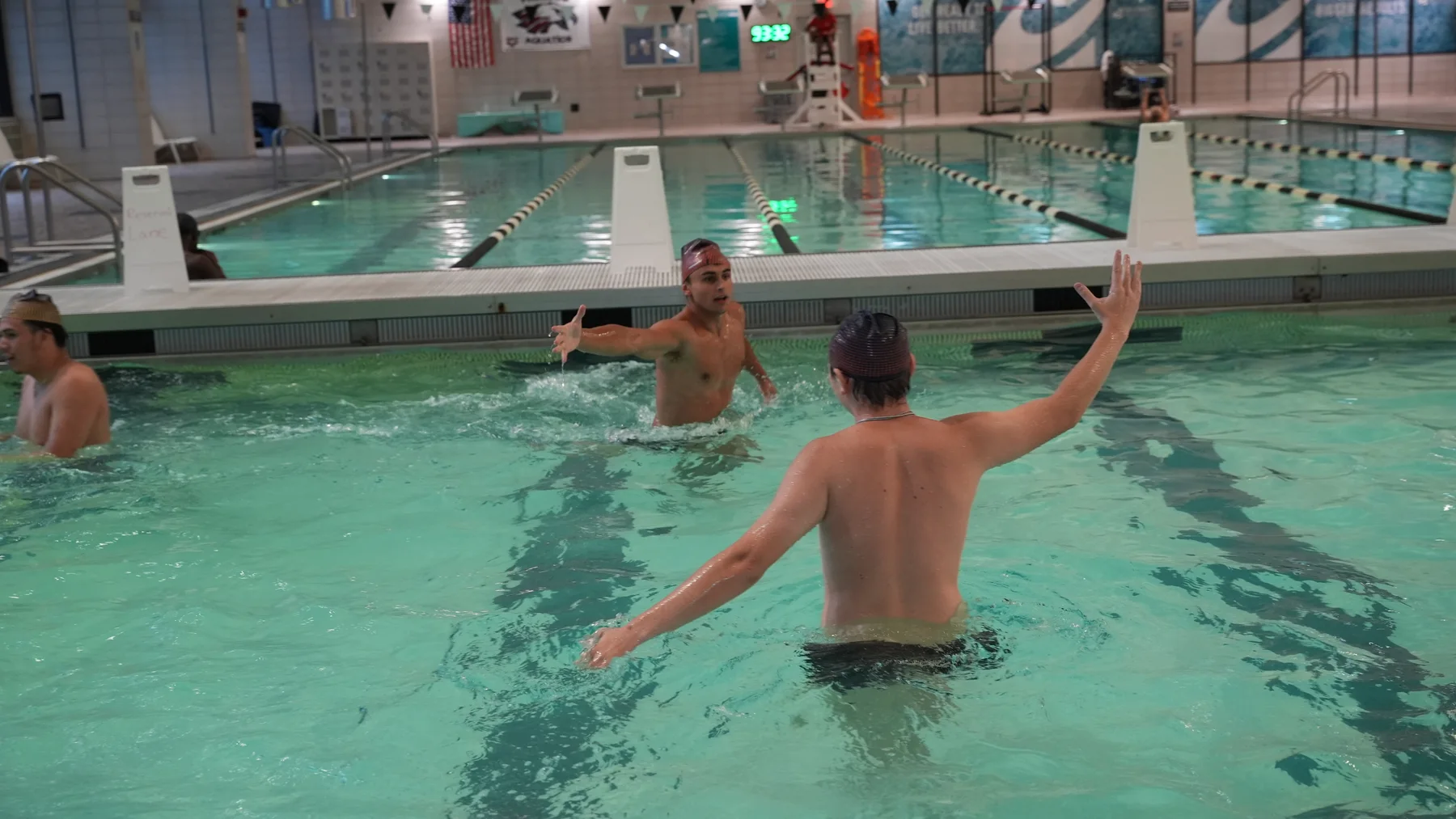 Two players face one another with their arms raised in the water.